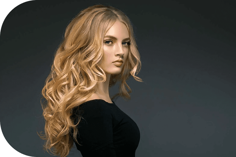 Woman with long, blonde curly hair showcasing a professionally styled salon hairstyle