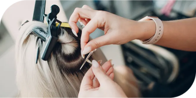 Stylist installing hair extensions using precise sectioning and clips