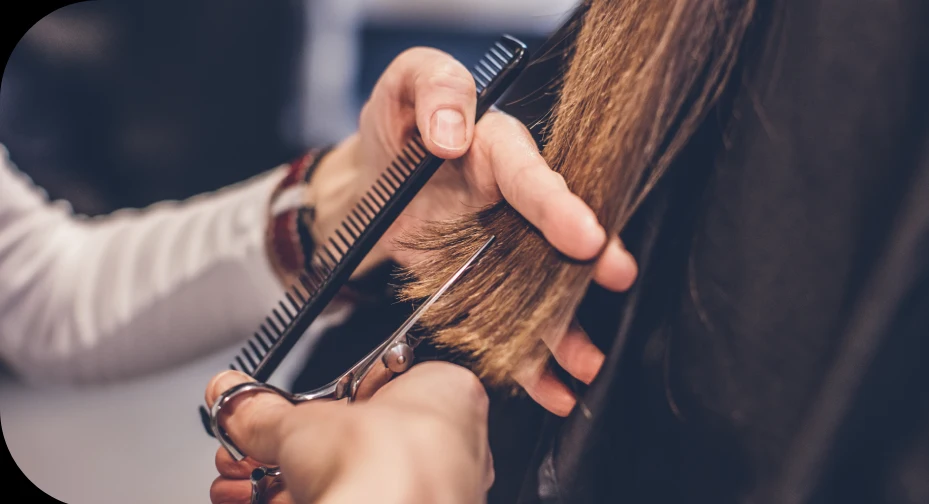 Stylist cutting a client’s hair with scissors and a comb