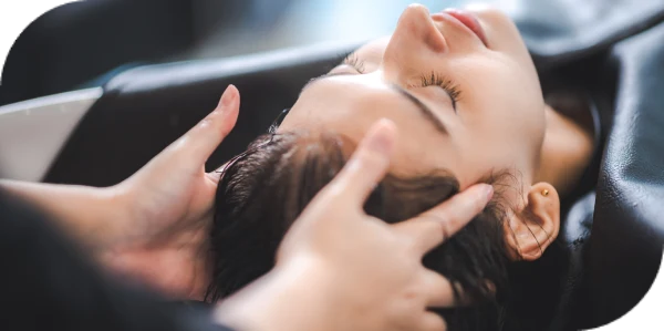 Client receiving a relaxing scalp massage during deep conditioning treatment