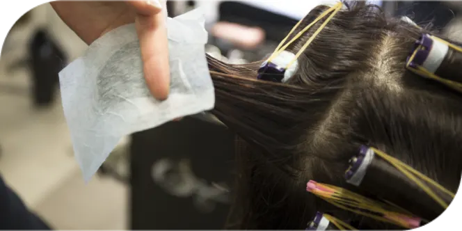 Close-up of perm rods and end papers used during a salon perm service