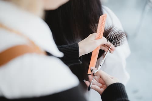 Hairstylist cutting hair during professional salon service