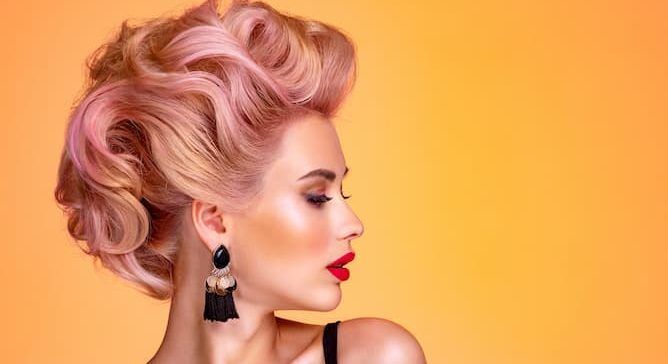Model with glamorous pastel pink hairstyle and bold makeup
