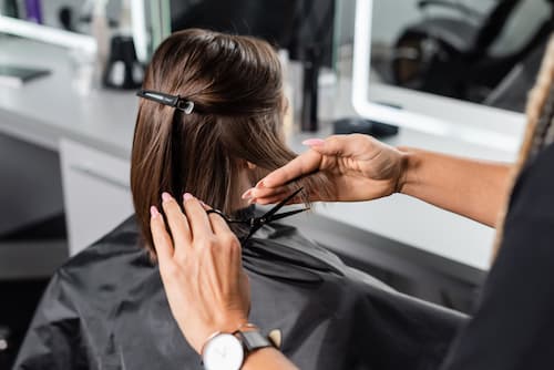 Hairdresser trimming sectioned hair during a salon haircut